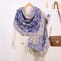 Dettaglio della sciarpa jacquard paisley blu e beige con nappe decorative su cappotto di lana - Blu Zaffiro