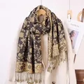 Detail of vintage paisley jacquard scarf with fringes on a wool coat - Coffee