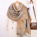 Dettaglio di sciarpa vintage con motivo paisley e frange, abbinata a un cappotto beige - Red Rice Camel