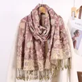 Dettaglio di sciarpa con motivo Paisley rosso vintage e frange su un cappotto bianco - Rosa Antico