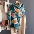 Dettaglio del motivo jacquard a margherita e frange sulla sciarpa di cashmere verde - Margherita Blu Lago