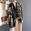 Detail of elegant black and gold floral cashmere shawl with fringe trim on wool coat - Black