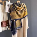 Detail van florale zonnebloem pashmina sjaal met franjes op beige jas - Vlinderbloem Goud