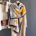 Dettaglio di una sciarpa a fiori in finto cashmere su un cappotto con frange - Foglia d'Oro Autunnale Blu