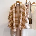 Bufanda clásica de lana a cuadros para mujer con flecos en una percha de madera con abrigo - Beige