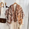 Ethnic knit shawl with brown geometric wave patterns and fringes over a beige coat - Brown