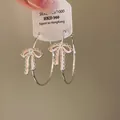 Orecchini a cerchio in argento con fiocco in smalto rosa e pietre di zirconi chiari - 46# Orecchini a Cerchio Argento con Fiocco in Smalto Rosa e Zircone