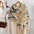 Ethnic wave pattern cashmere scarf in yellow and grey with fringe on a beige coat - Yellow