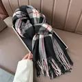Classic red black and white plaid scarf with fringe on an elegant tray and leather background - Black