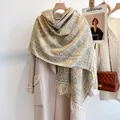 Dettaglio sciarpa a quadri geometrici con lunghe frange e trama spessa su cappotto beige - Giallo