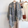 Dettaglio di uno scialle vintage a quadri con motivi a maglia e lunghe frange su gruccia - Grigio