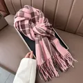 Close-up of pink and brown plaid scarf featuring soft cashmere-like texture and tassel trim - Pink