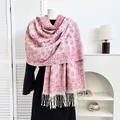 Close-up of pink paisley cashmere scarf with delicate tassels on a black coat - Rose Red