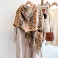 Detailed texture of paisley pattern pashmina shawl with fringe on elegant coat - Camel
