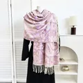 Detalle de chal pashmina con estampado paisley morado y flecos sobre un abrigo - Paisley Púrpura