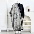 Close-up of ethnic style printed scarf with fringe detail on a black coat display - Navy Blue