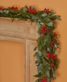 Detalle de guirnalda navideña con agujas de pino y bayas rojas sobre una chimenea - Guirnalda de Bayas Rojas de Eucalipto (Con Luz)