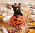 Detail einer handgefertigten schwarzen Katze mit Kürbishut auf geschnitztem Halloween Kürbis - Kürbis-Stil
