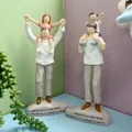 Detalle de figuras de resina de padres e hijos con grabado de gratitud en español en la base - Padre E Hijo