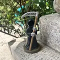 Detail of resin Grim Reaper figurine holding a scythe with Go You text engraving - Grim Reaper with Scythe