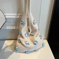 Schicke cremefarbene Strick-Einkaufstasche mit lebhaften blauen und gelben 3D-Blumen - Blau