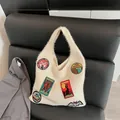 Beige plush knit tote bag with vintage cryptozoology embroidery patches on a chair - Off White
