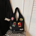 Black plush knit tote bag featuring colorful embroidered cryptid patches and a fuzzy texture - Black
