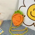Macro detail of hand-knitted carrot bag showing textured orange crochet stitch and green leaf - Carrot Orange