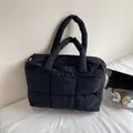 Borsa tote imbottita nera minimalista con finitura in nylon trapuntato e tracolla - Nero