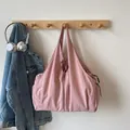 Light pink pleated nylon shoulder bag with side pockets on a minimalist wall hanger - Pink