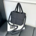Chic black quilted puffer tote bag with padded handles and strap on aesthetic books - Black