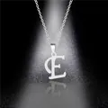 Detailed view of polished stainless steel silver letter E pendant necklace on dark surface - Letter E