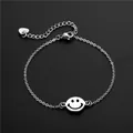 Bracelet minimaliste en acier inoxydable 304 avec pendentif smiley sur fond noir - Visage Souriant (SL80)