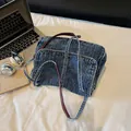 Sac bandoulière en denim bleu délavé avec lanières en cuir marron et boucles métalliques - Bleu