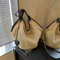 Strohgewebte Strandtasche mit schwarzen Ledergriffen und Herzanhänger in Holzfarbe - Schwarz