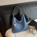 Blue canvas tote bag with white letter embroidery and a brown leather coin purse charm - Blue