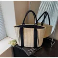 Detailed close-up of woven straw tote bag with black canvas straps and drawstring closure - Plain Style / Off White