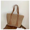 Detail of hand-woven beige straw tote bag featuring brown leather straps and twin tassels - Khaki