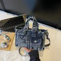 Bolso de mano vintage en mezclilla azul lavada con correa ajustable y varios bolsillos - Azul Denim