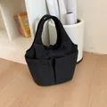 Sac à main minimaliste en tissu matelassé noir avec doubles poches sur parquet - Style Matelassé Multi-poches / Noir