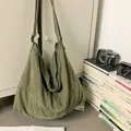 Detalle del bolso hobo de lona verde militar con correa ajustable y estilo vintage - Verde