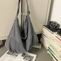 Detalle de bolso hobo de lona gris oscuro con correa ajustable y textura vintage - Gris