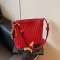 Dark red woven bucket bag with intricate leather craftsmanship and bead charm accessory - With Pendant / Red