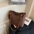 Brown woven bucket bag with knotted strap, metallic rings, and beaded tassel charm - With Pendant / Brown
