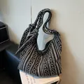 Ethno-Strick-Schultertasche mit schwarz-weißem Stickmuster und geknotetem Riemen - Schwarz
