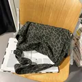 Borsa a tracolla in tela leopardata verde scuro su una sedia pieghevole in legno - Verde Leopardato