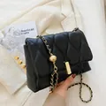 Chic black wave-quilted shoulder bag with gold chain strap and metal ball buckle - Black