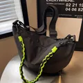 Black nylon crescent bag with neon green woven strap and adjustable shoulder band - Black