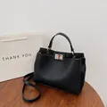 Sac Kelly en cuir noir grainé avec boucle dorée et bandoulière réglable pratique - Noir Litchi