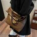 Detail of vintage brown leather tote bag showing rope handles and matte texture finish - 34x13x42 / Brown